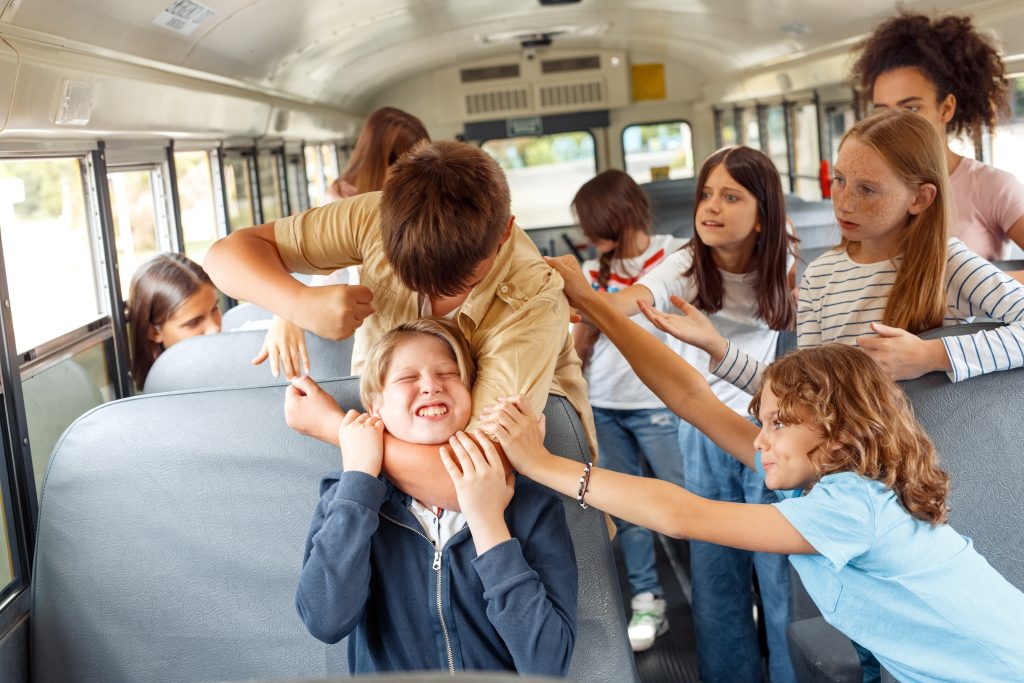 Group of children classmates going to school by bus boy strangling kid punching angry while others trying to stop him from violence