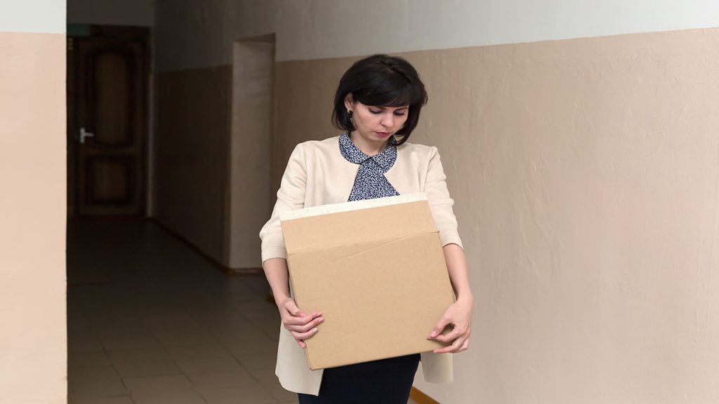 A frustrated teacher with a box in his hands quits.