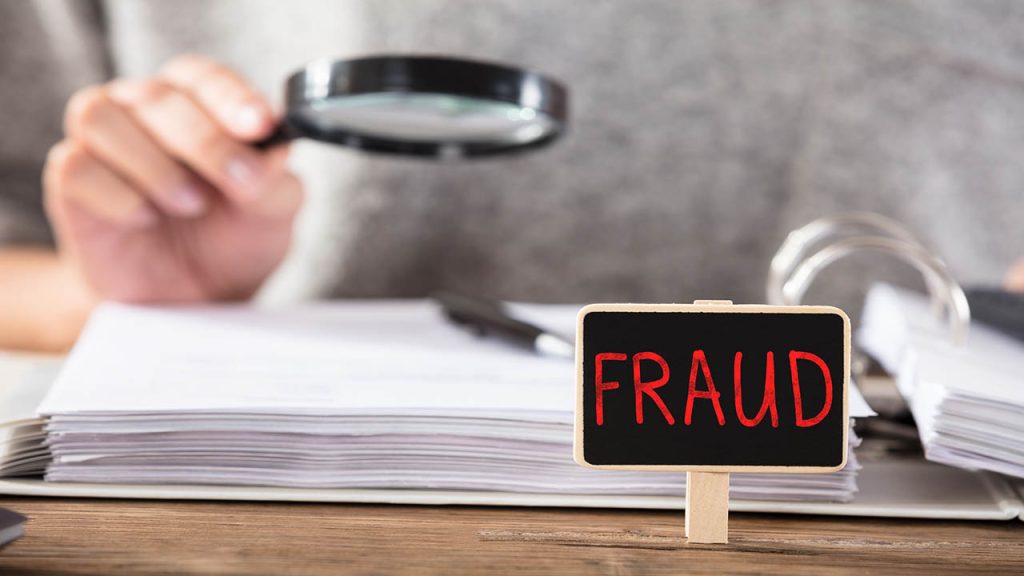 Businesswoman Checking Documents With Fraud Board On Desk